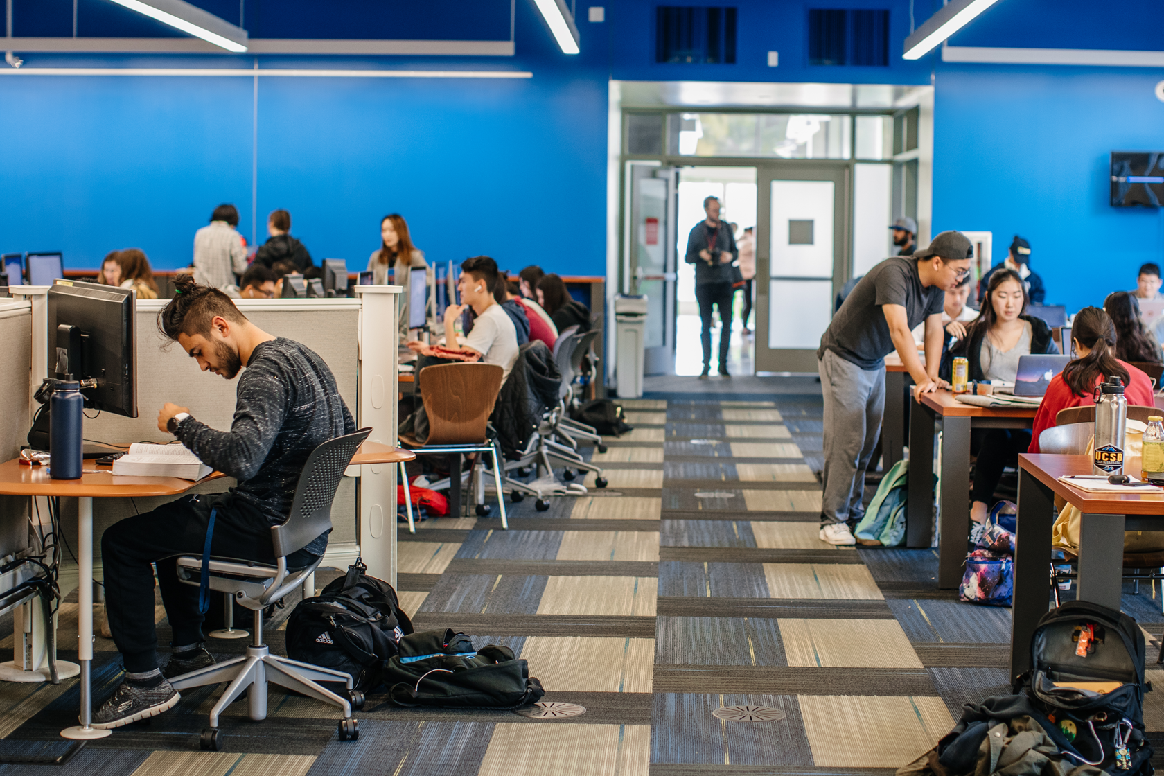 Students in a common space using desktops and laptops